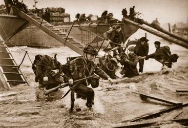 Die ersten britischen Truppen landen mit speziell entworfenen Landungsleitern. In der Mitte tragen Soldaten einen Roller, 6. Juni 1944